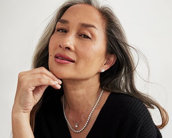 Asian female wearing white blazer and square diamond stud earrings